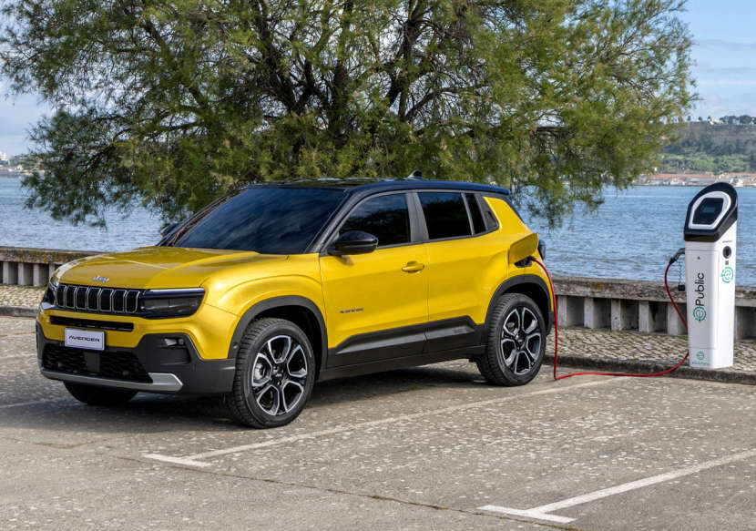 Jeep Avenger Electric жовтого кольору заряджається на стоянці біля моря